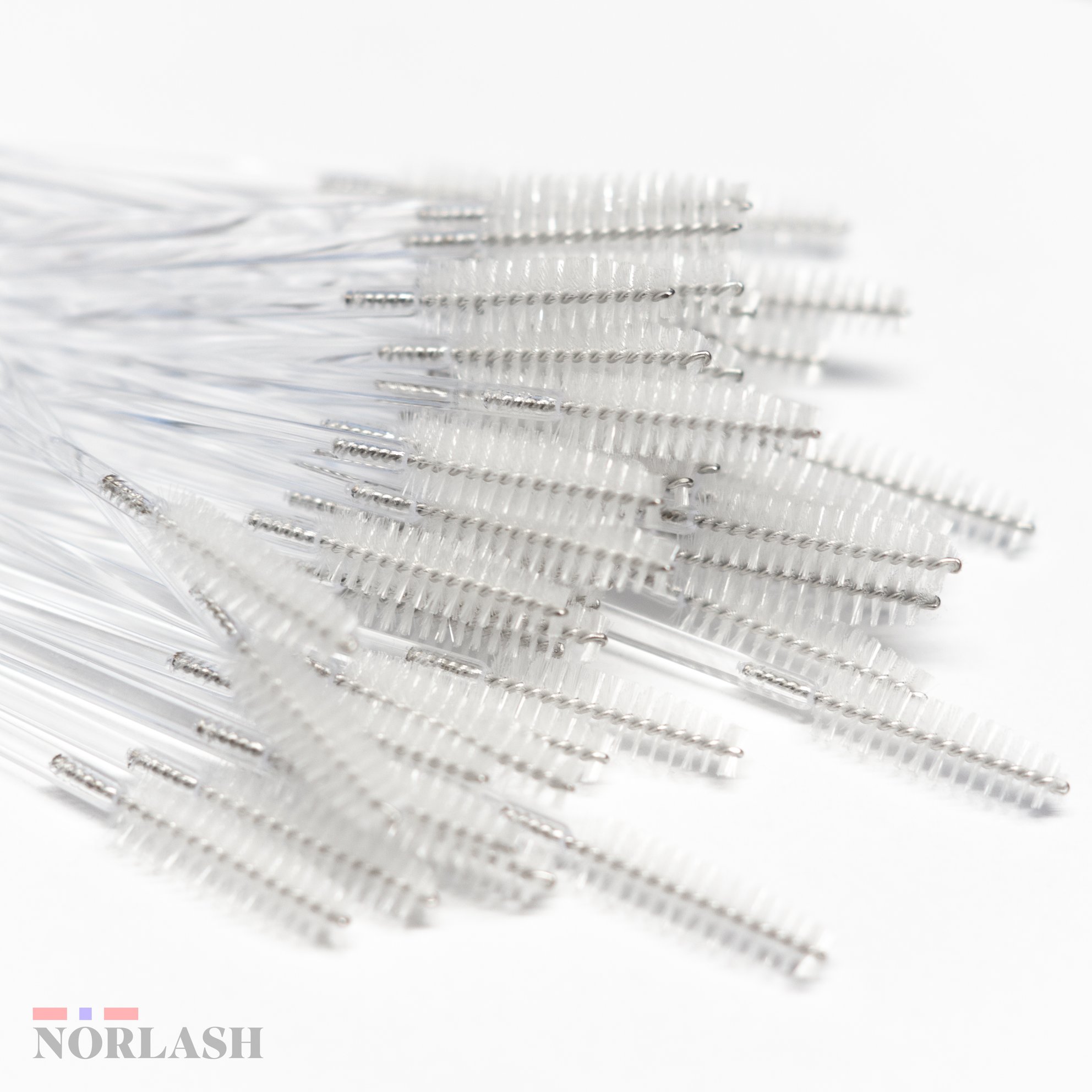 A pile of 50 mascara brushes on a white background